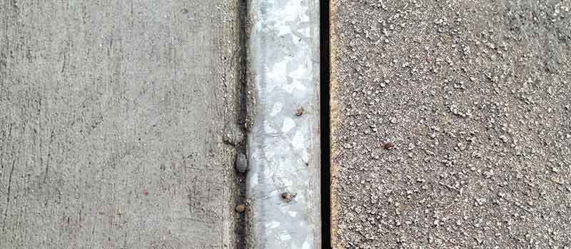 The texture and shading on a sidewalk.